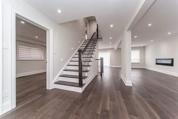 A new staircase with dark treads, white risers and a black metal railing.
